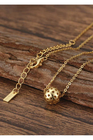 detail of realistic gold pickleball necklace