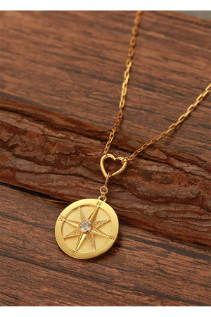 we wander compass pendant necklace on wood 